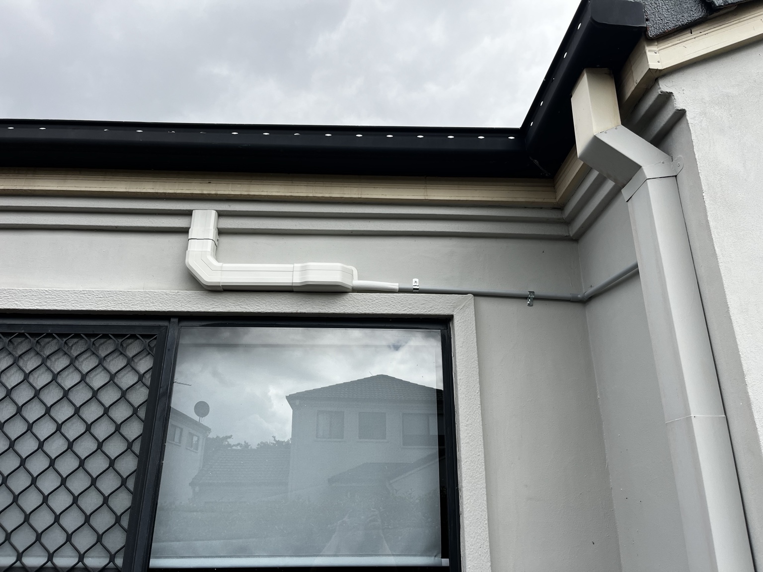 External pipe cover and services routed around the front corner towards the side of the home