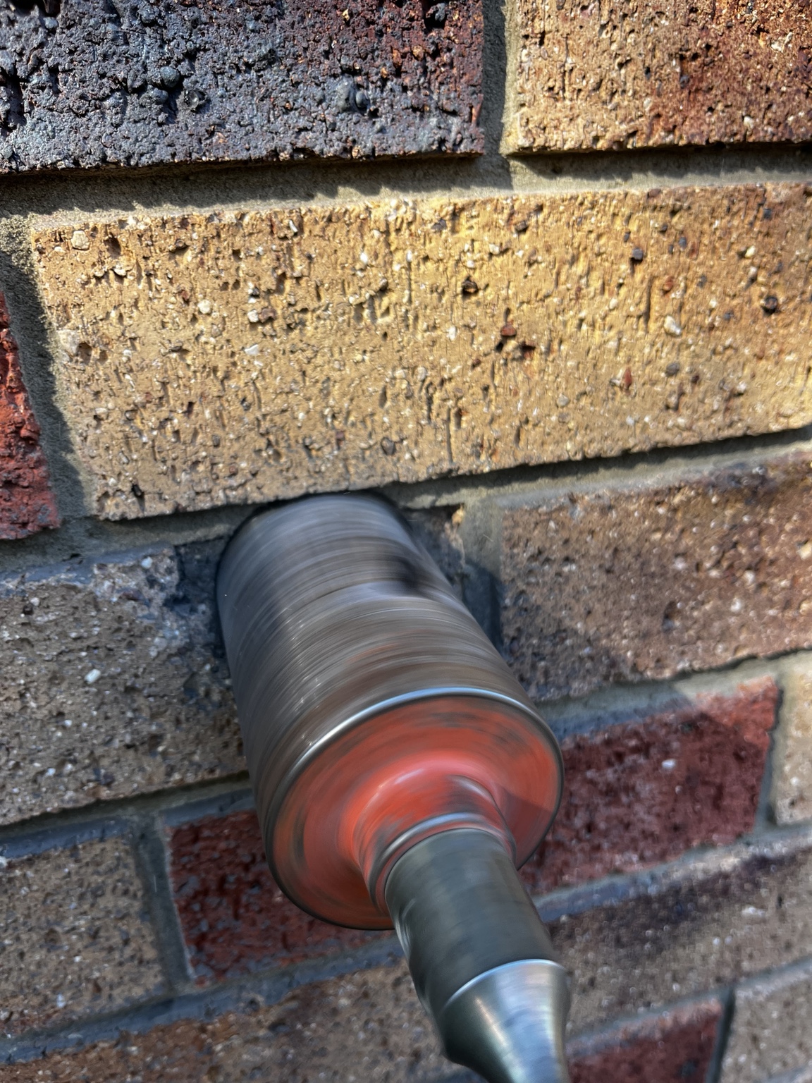 Core drilling a brick wall for split-system pipework