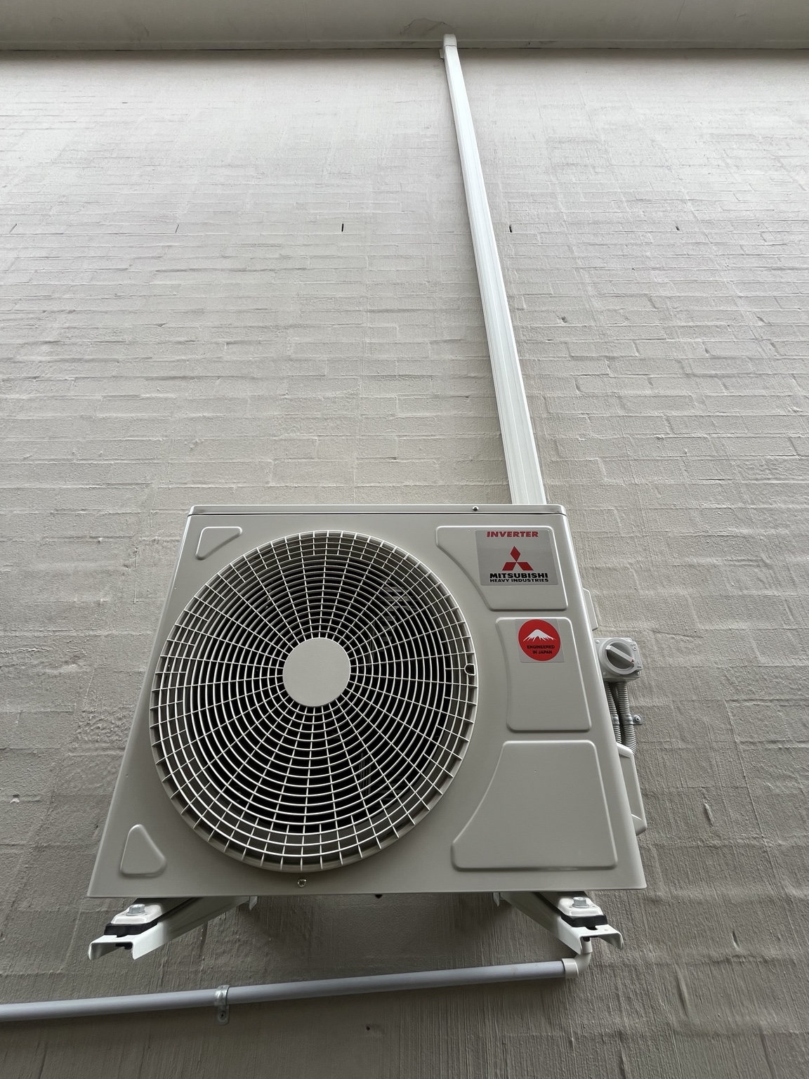 Single Mitsubishi Heavy Industries outdoor unit wall-mounted with neat service cover by Swind